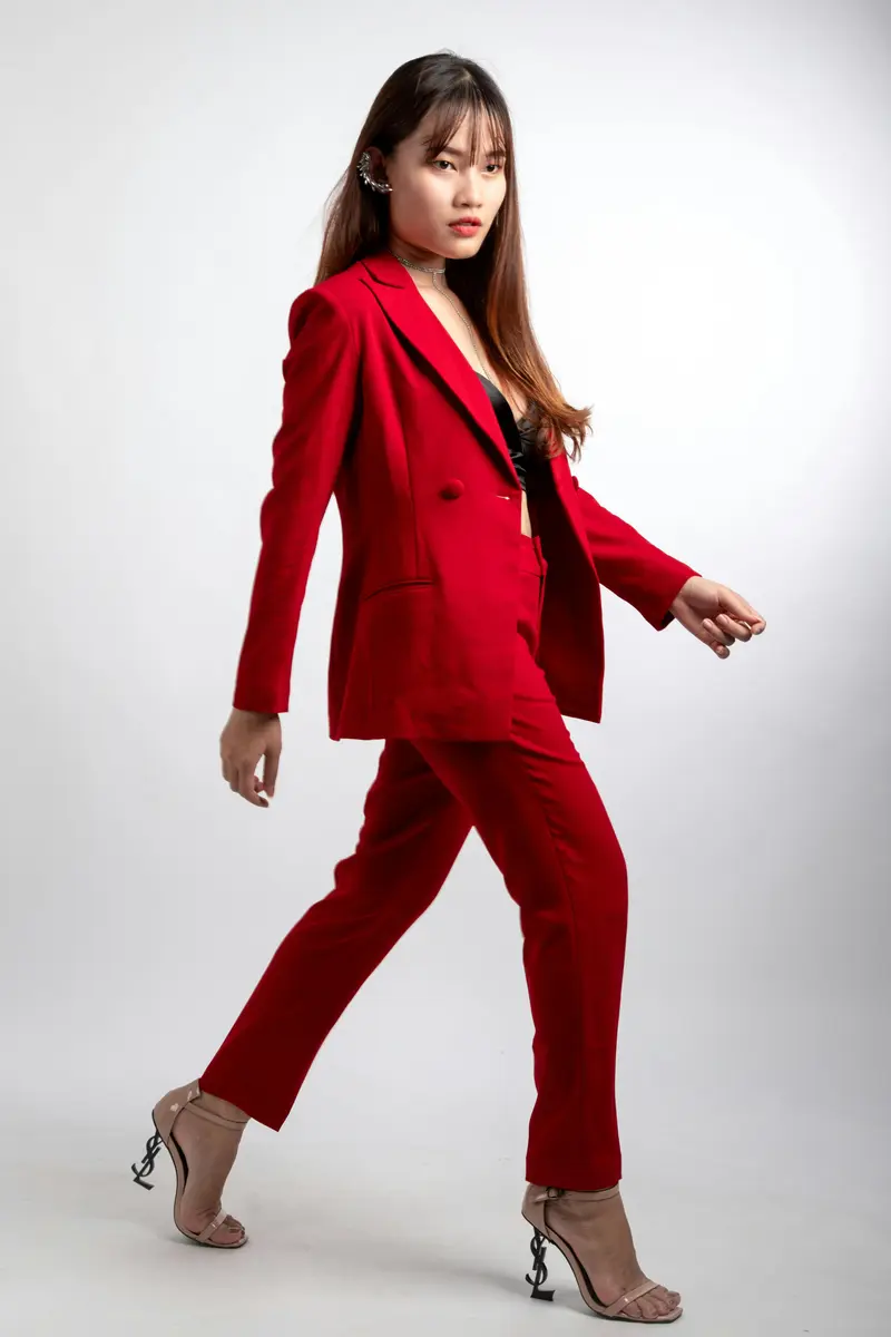 Woman in a red suit walking on white background